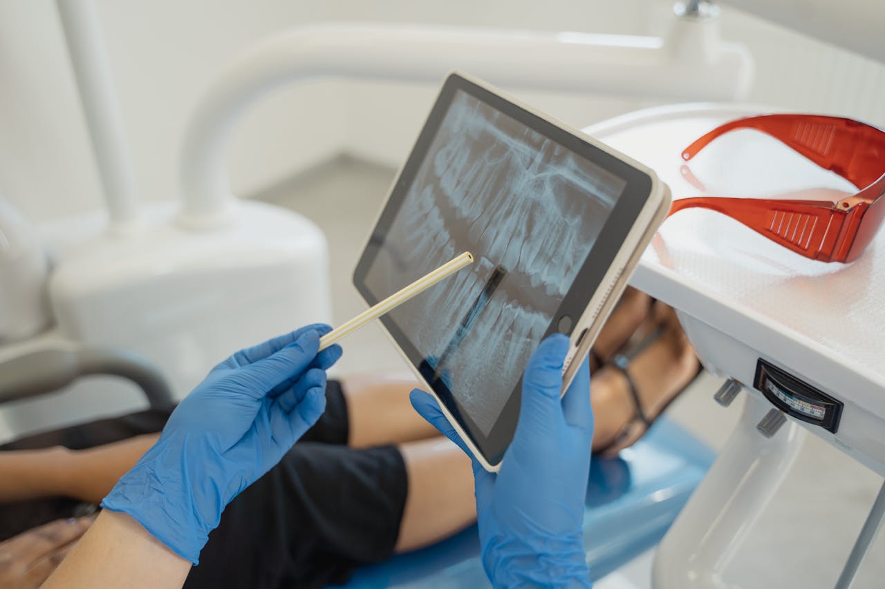 hero-gallery-03 Dentist showing dental x-ray on tablet to patient in a modern clinic setting.